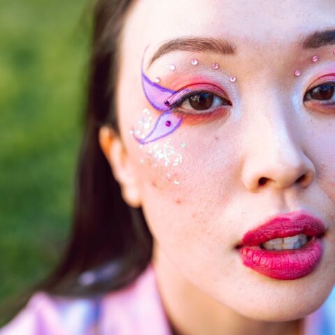 trans women butterfly makeup photoshoot in grass